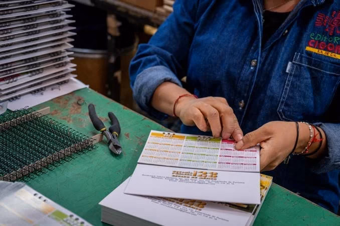 Encuadernación manual con espiral de una publicación en el taller de CIGOME