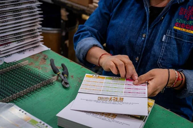 Encuadernación manual con espiral de una publicación en el taller de CIGOME