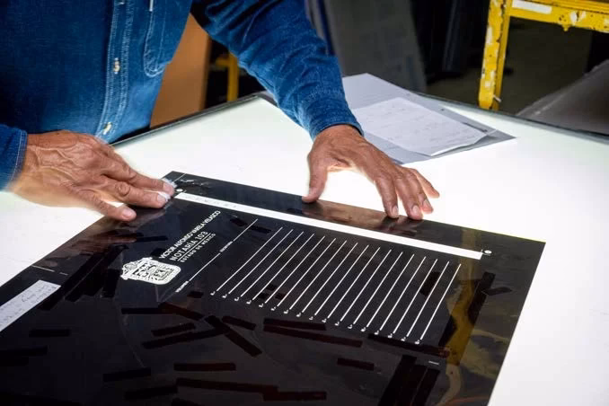 Revisión de una lámina para impresión offset sobre una mesa de trabajo en CIGOME