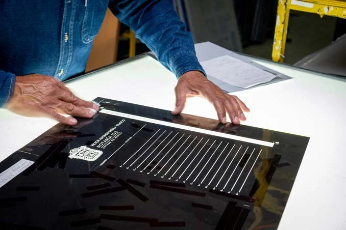 Revisión de una lámina para impresión offset sobre una mesa de trabajo en CIGOME