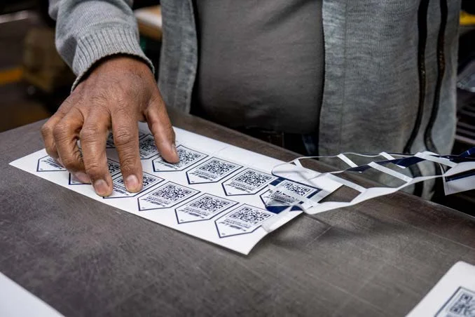 Revisión manual de hojas impresas con etiquetas en el taller de Editorial CIGOME